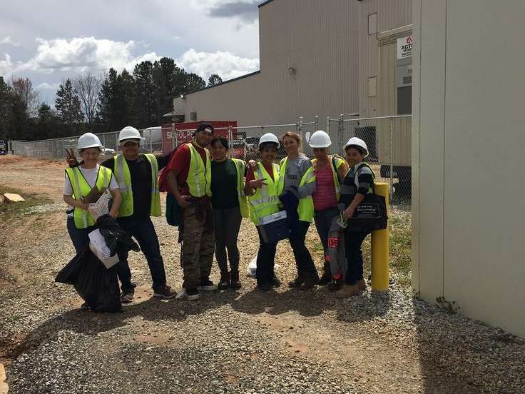 A group of construction workers are posing for a picture in front of a building.