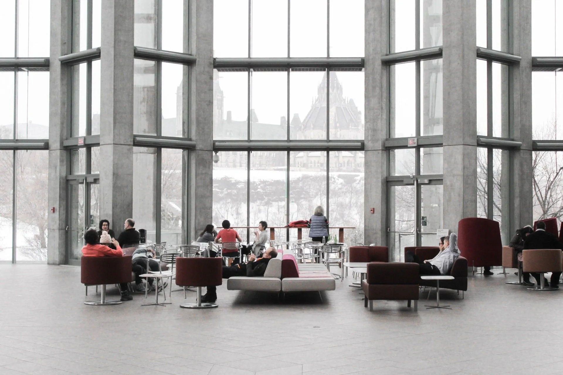 An empty office with tables and chairs and a lot of windows.
