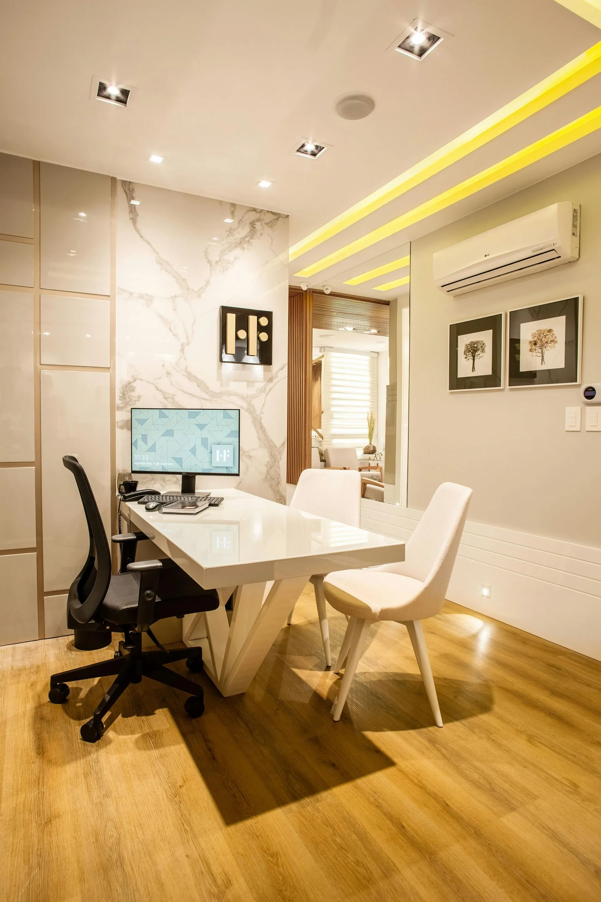 A room with a desk and chairs and a computer on it.