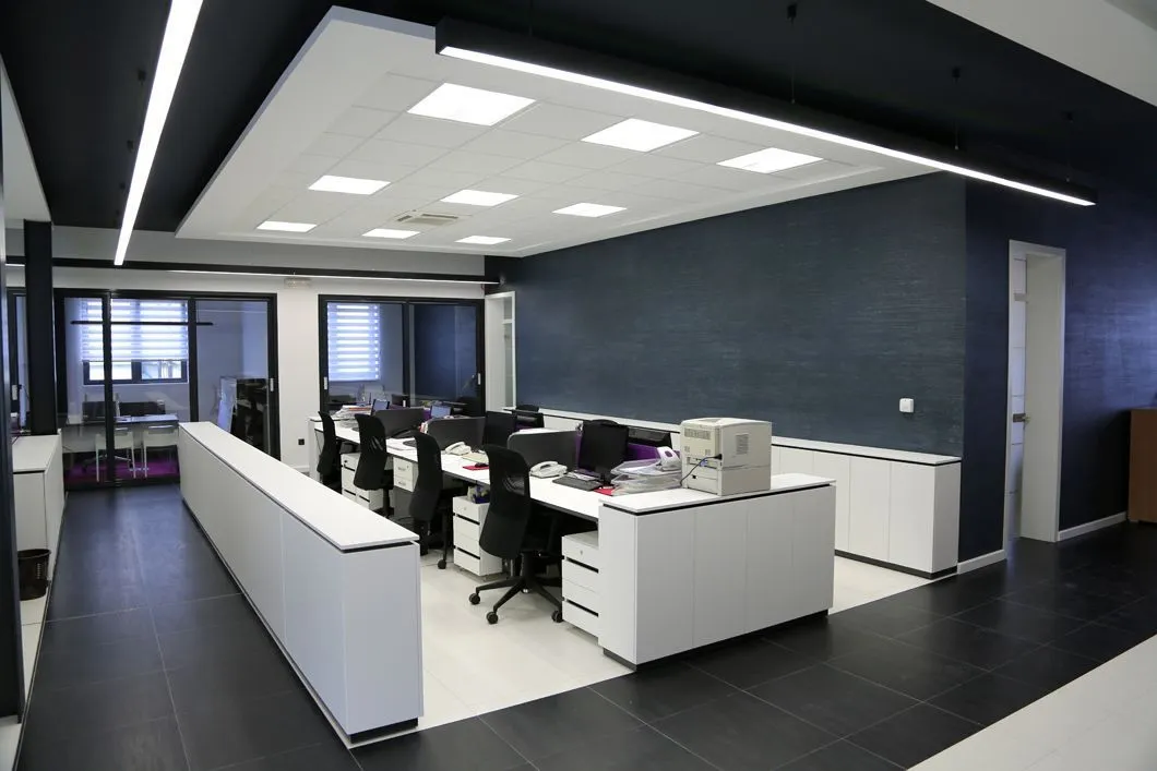 A large office with a lot of desks and chairs.