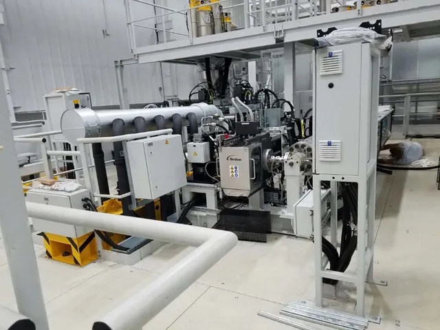 A large machine is sitting in a room in a factory.